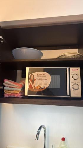 a microwave sitting on a shelf in a kitchen at Aeon tower Davao exclusive studio unit in Davao City