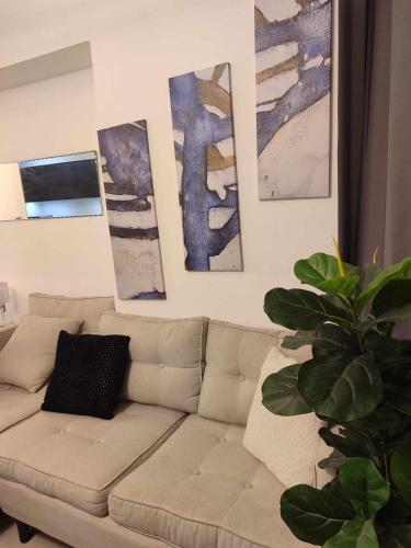 a living room with a couch and paintings on the wall at Aeon tower Davao exclusive studio unit in Davao City
