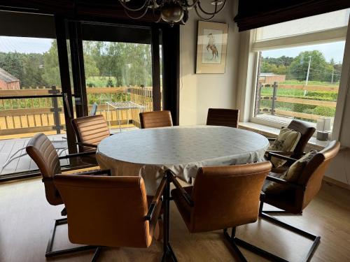a dining room with a circular table and chairs at Welkomhoeve in Grobbendonk