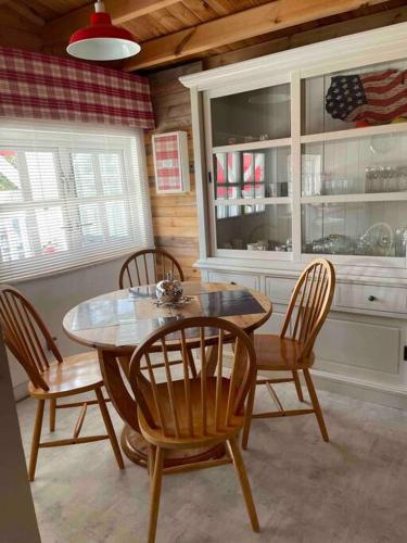 une salle à manger avec une table et quatre chaises dans l'établissement Love spa jacuzzi en amoureux à 30 min de bordeaux, à Pissos