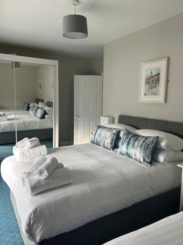 a bedroom with two beds and a large mirror at No 12 Bridge Street - Town Centre Apartment in Westport