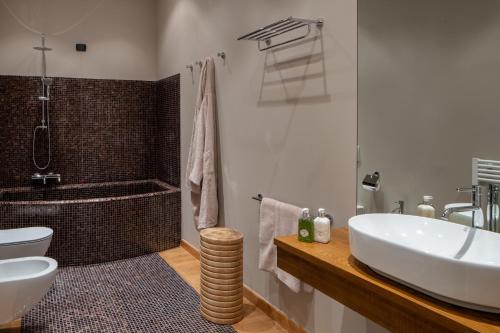 a bathroom with a tub and a sink and a toilet at Precise Tale Poggio Alla Sala in Montepulciano