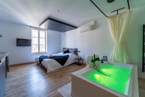 - une chambre avec un lit et une baignoire verte dans l'établissement La nuit sous les étoiles, à Nancy