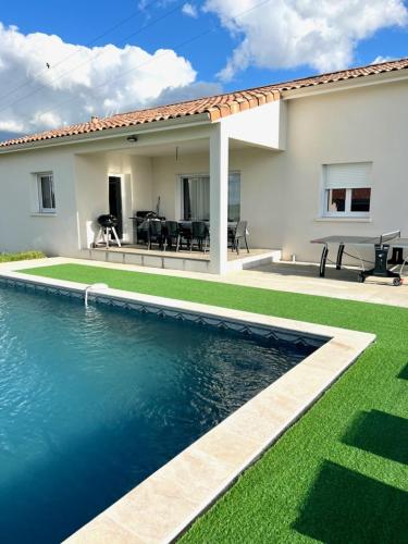 une maison avec une piscine devant une maison dans l'établissement Gîte pour 8 personnes, à Frespech