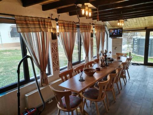 a long dining room with a long table and chairs at Къща за гости РАЙ 10човека in Boykovtsi