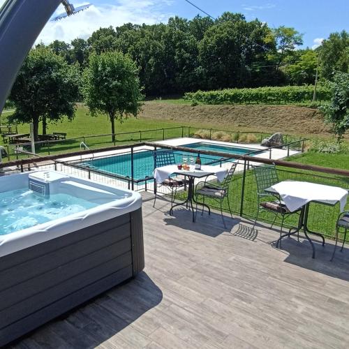 a swimming pool with a table and chairs next to a swimming pool at Le Vigne di Adamo in Volta Mantovana