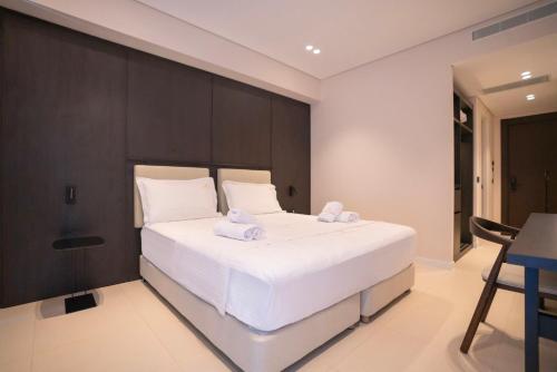 a bedroom with a large white bed with towels on it at DREAM HOTEL SARANDA in Sarandë