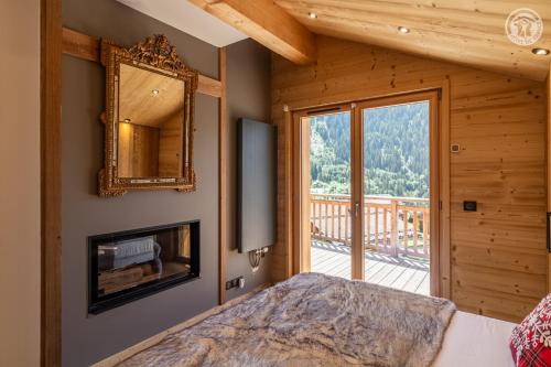 - une chambre avec un lit, un miroir et un balcon dans l'établissement 200 m des télécabines, Cheminée & Cosy, à Champagny-en-Vanoise