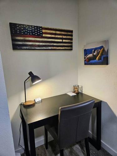 a desk with a lamp and an american flag on the wall at Madrona's Cottage A in Charleston