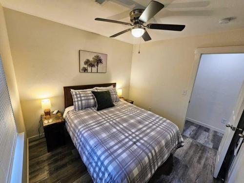 a bedroom with a bed with a ceiling fan at Madrona's Cottage A in Charleston