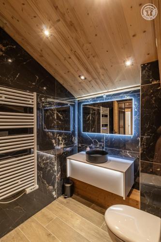 une salle de bain avec un lavabo blanc et des toilettes dans l'établissement 200 m des télécabines, Cheminée & Cosy, à Champagny-en-Vanoise