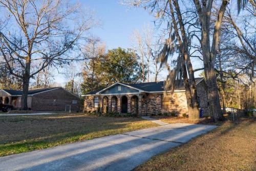 a stone house with a tree next to a road at Madrona's Cottage A in Charleston