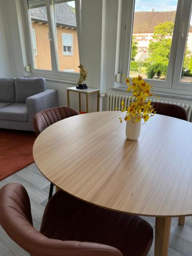 a wooden table with a vase of flowers on it at Isaak Apartment Schlossblick in Waldshut-Tiengen