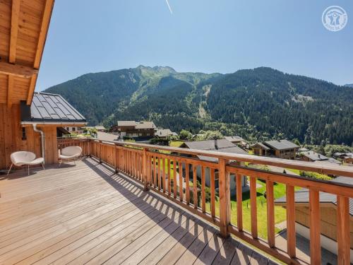 une terrasse en bois avec vue sur une montagne dans l'établissement 200 m des télécabines, Cheminée & Cosy, à Champagny-en-Vanoise