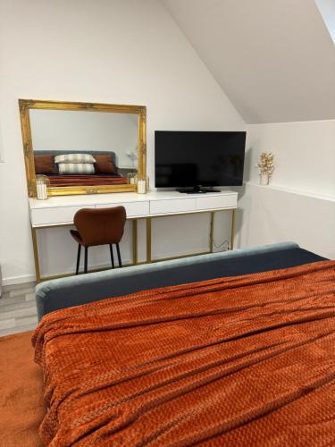 a bedroom with a bed and a desk with a mirror at Isaak Apartment Schlossblick in Waldshut-Tiengen