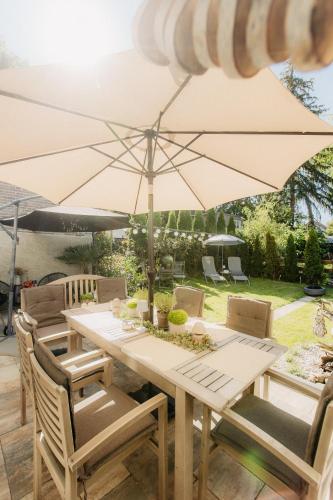a wooden table with an umbrella on a patio at PauliDrei in Leipzig