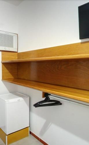 a wooden shelf with a television on top of it at Hotel Xapuri in Peruíbe