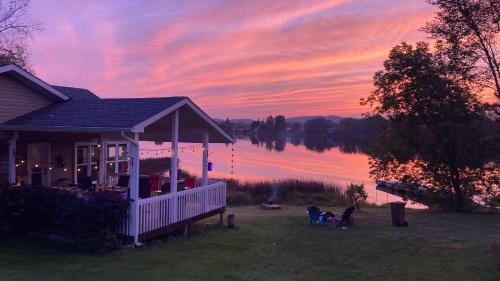 une maison sur la rive d'un lac au coucher du soleil dans l'établissement Le Duc on the Lake - Cozy waterfront Cottage, à Saint-André-Avellin