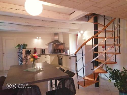 une cuisine avec un escalier en colimaçon au milieu d'une pièce dans l'établissement Gite de l'Esperance, à Cantelaube