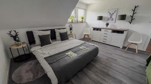 a bedroom with a large bed and a dresser at Ferienwohnung Eifelglück in Pelm