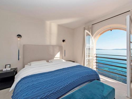 une chambre avec un grand lit et une grande fenêtre dans l'établissement Propriété de luxe en bord de mer, à Grimaud