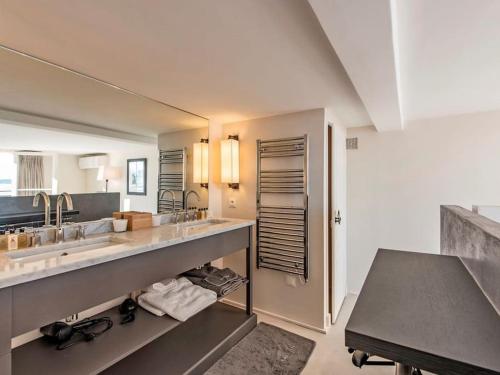 une salle de bain avec deux lavabos et un grand miroir dans l'établissement Propriété de luxe en bord de mer, à Grimaud