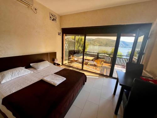 a bedroom with a bed and a balcony with a view at Pensiunea Maria Teodora in Eşelniţa
