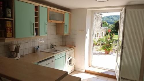 a kitchen with a sink and a washing machine at CHEZ PIERRE in Remoncourt