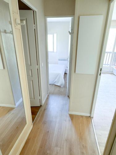 - un couloir avec un miroir et un lit dans une chambre dans l'établissement Valmeinier, à Valmeinier