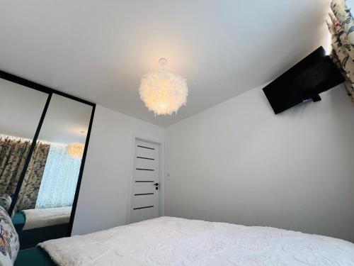 a bedroom with a bed and a chandelier at Sparrow apartmens - Superior family in Košice
