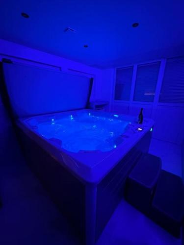 a blue room with a hot tub in it at F & C Love Spa, Sauna and Tantra in Chartrettes