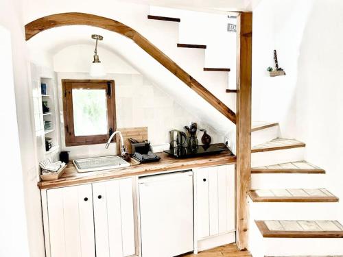 een keuken met witte kasten en een trap bij Preciosa casa con terraza in Vejer de la Frontera