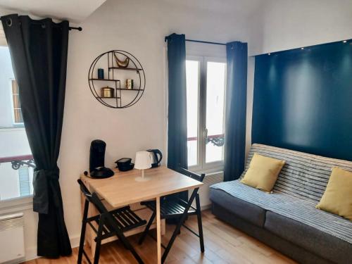 Cette chambre comprend un lit, une table et un bureau. dans l'établissement Très joli Studio - centre Paris - Le Coeur du Marais, à Paris