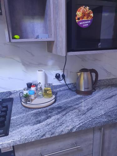 a counter top with a tea pot and a kettle at Modern and cozy apartment in Lusaka
