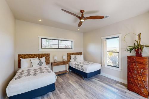 a bedroom with two beds and a ceiling fan at Waikoloa in Waikoloa