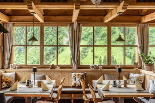 a restaurant with tables and chairs and windows at Gasthaus Ursprung in Damuls