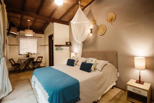 a bedroom with a bed with a blue blanket at Bonito Paraiso Ilha Grande in Abraão
