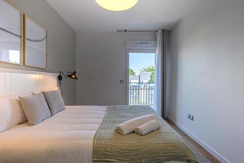 een slaapkamer met een groot wit bed met een raam bij OVELIA Fouesnant - Les Allées de Kervihan in Fouesnant