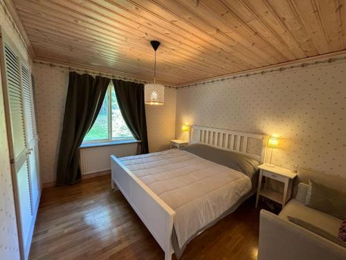 ein Schlafzimmer mit großem Bett und Holzdecke in der Unterkunft Emma's country cottage in southern Sweden in Älghult
