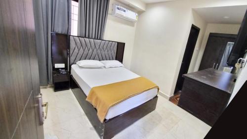 a bedroom with a bed and a dresser in it at Hotel Padma Vista Nellore Near Bus Stop in Nellore