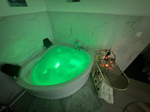 Una bañera verde en un baño con una bañera verde. en Apartman Mont, Lux & Jacuzzi - Jahorina, en Jahorina