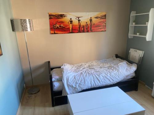 - une petite chambre avec un lit et une lampe dans l'établissement Appartement neuf au calme, à Mardié