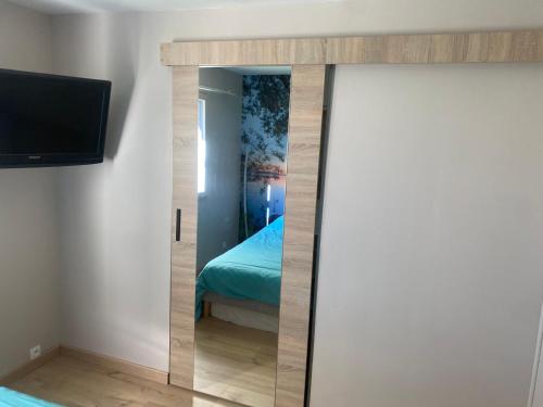 Cette chambre comprend un lit et une télévision. dans l'établissement Appartement neuf au calme, à Mardié