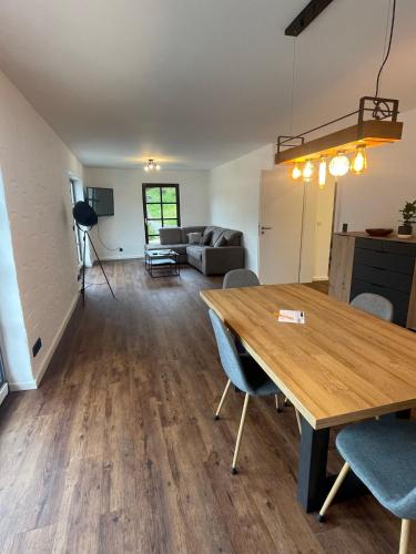 a dining room and living room with a table and chairs at Ferienwohnung Am Kreuzberg in Schleiden
