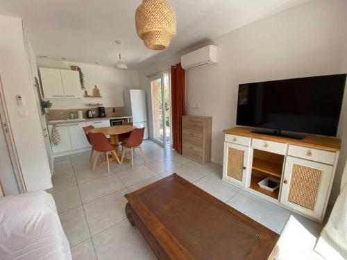a living room with a flat screen tv and a table at Casa Pépé Brouilla in Brouilla
