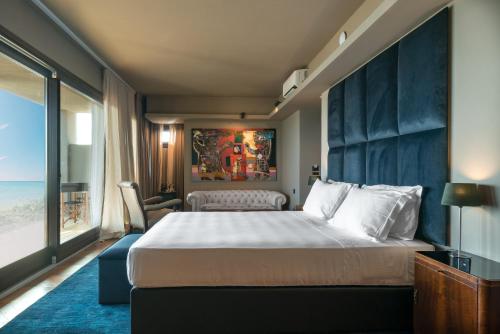 a bedroom with a large bed and a large window at Sunset Villa in Castiglione della Pescaia