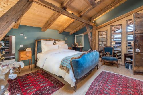 Un dormitorio con una cama grande en una habitación con techos de madera. en Le Mont Farm, en Servoz