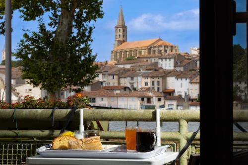 a tray of food on a table with a view of a city at Le Grand Bassin in Castelnaudary