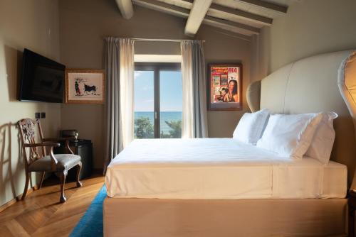 a bedroom with a large bed and a window at Sunset Villa in Castiglione della Pescaia