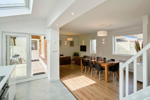 une salle à manger et un salon avec une table et des chaises dans l'établissement La Papeterie - Les Demeures d'Adrien, à Péronne-en-Mélantois